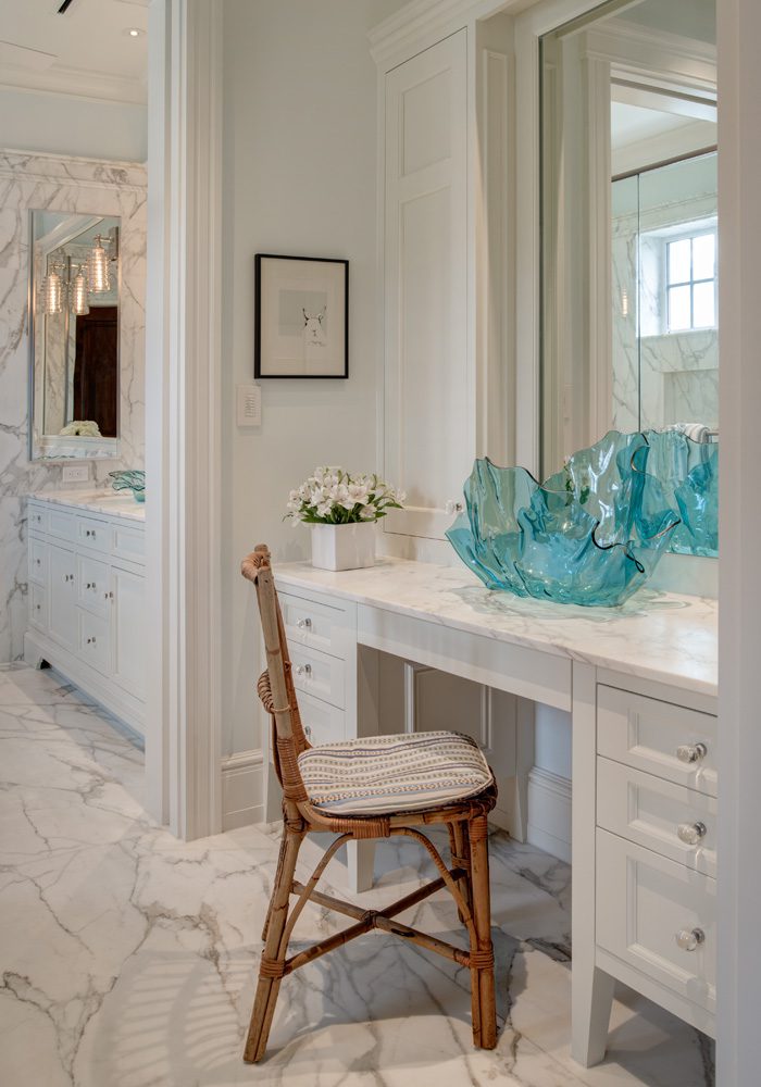 A bathroom with a vanity and chair in it