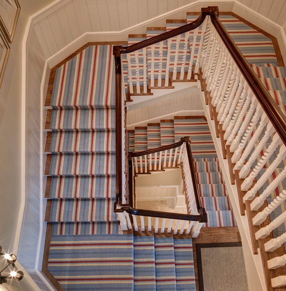 A staircase with blue and white striped carpet.