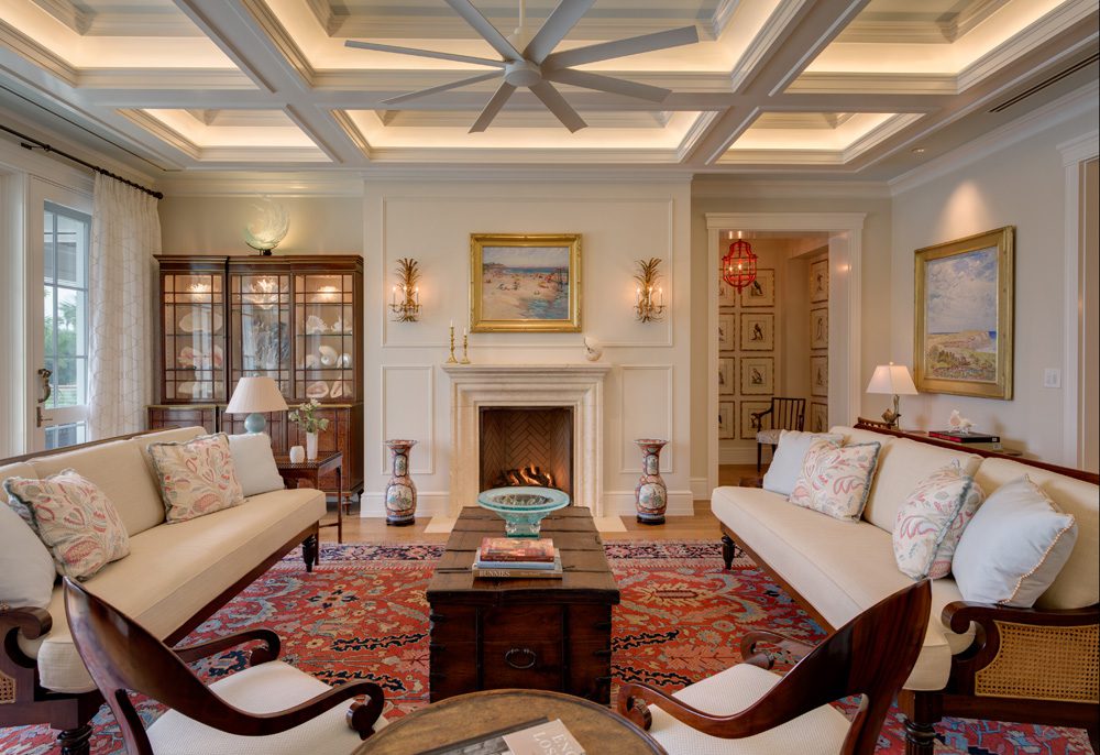 A living room with two white couches and a fireplace.