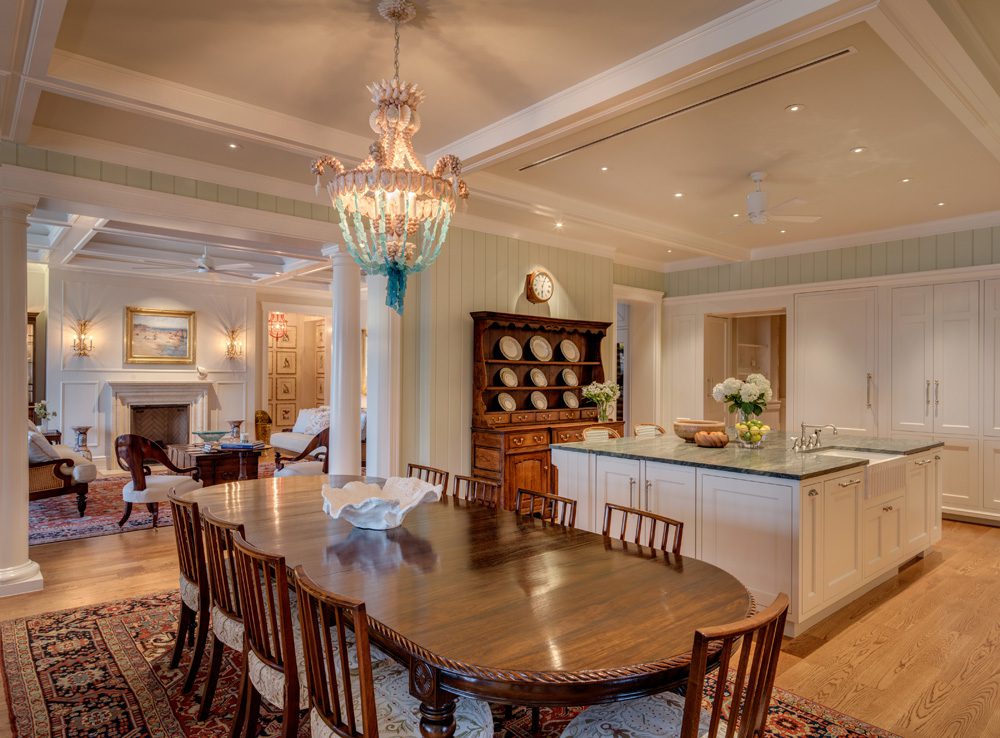 A dining room table and chairs in the center of a kitchen.