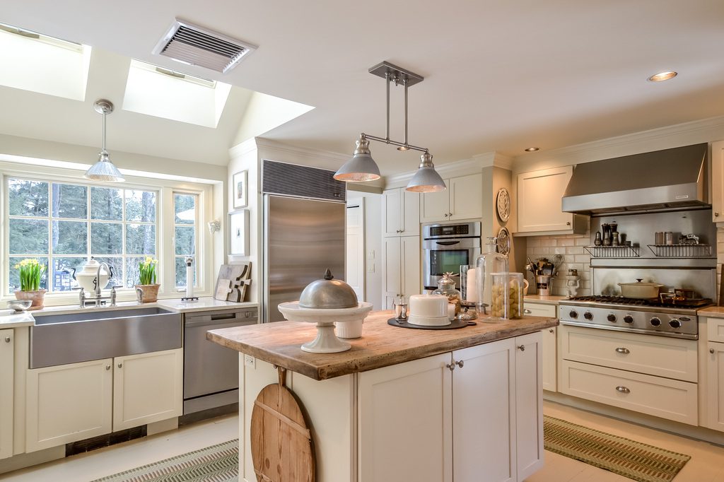 A kitchen with white cabinets and stainless steel appliances.