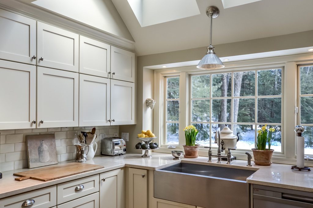 A kitchen with white cabinets and a sink.