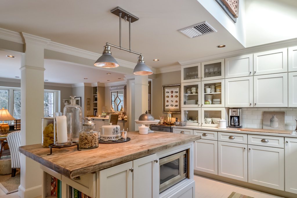 A kitchen with white cabinets and a microwave.