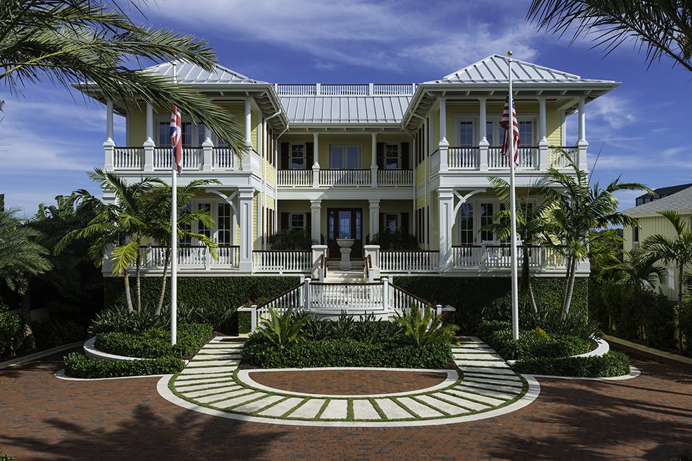 A large white house with palm trees in front of it.