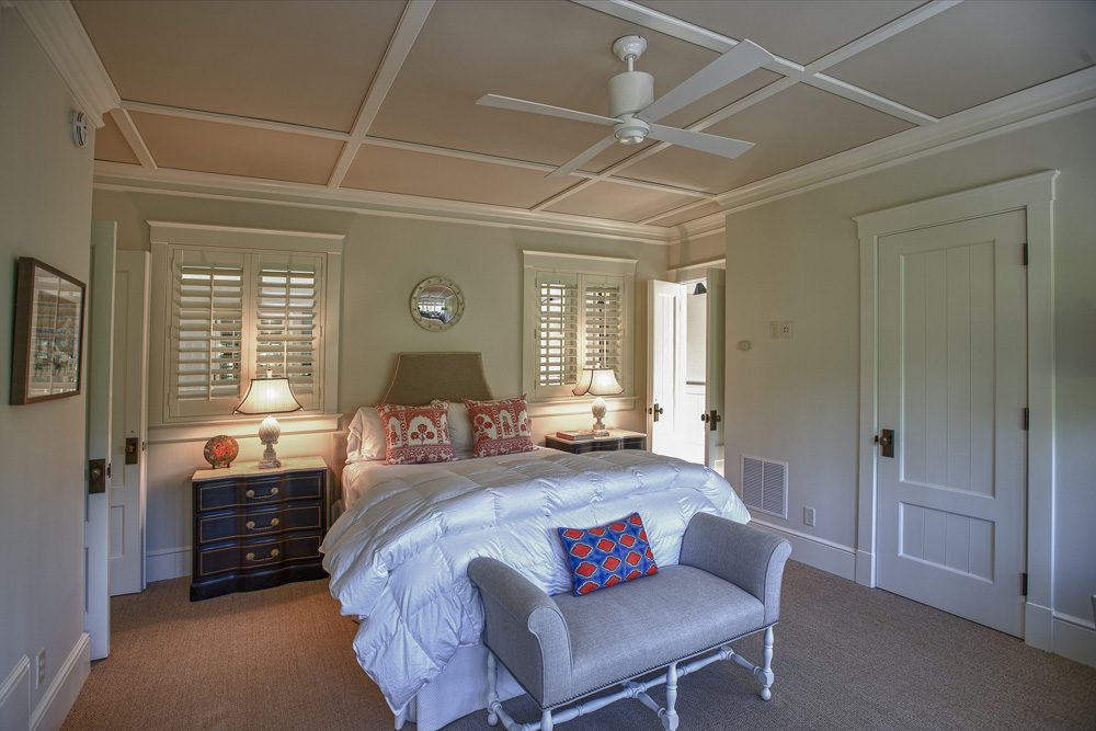 A bedroom with a bed, dresser and window.