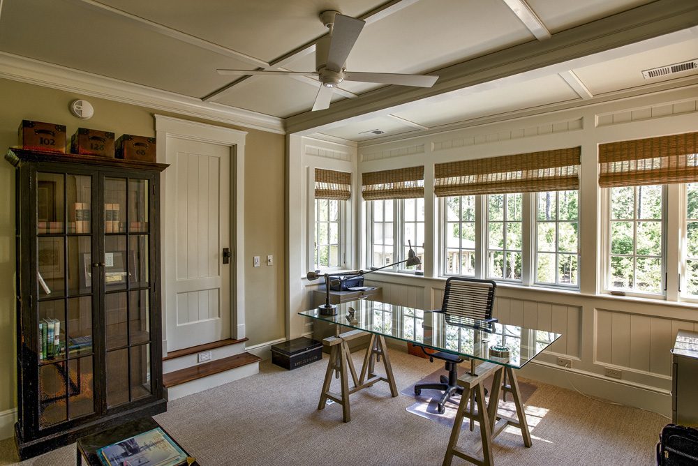 A room with two desks and a large window.