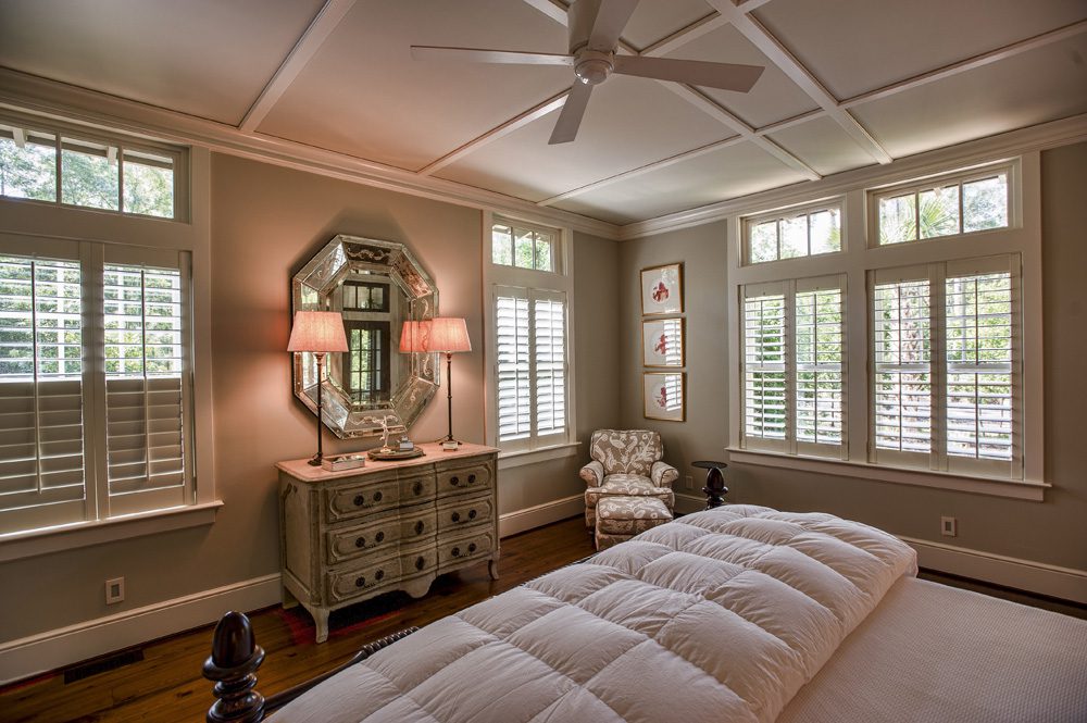 A bedroom with a bed, dresser and mirror.