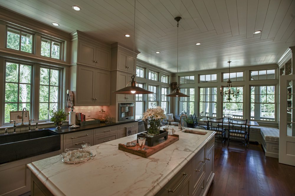 A kitchen with a large island and wooden floors.