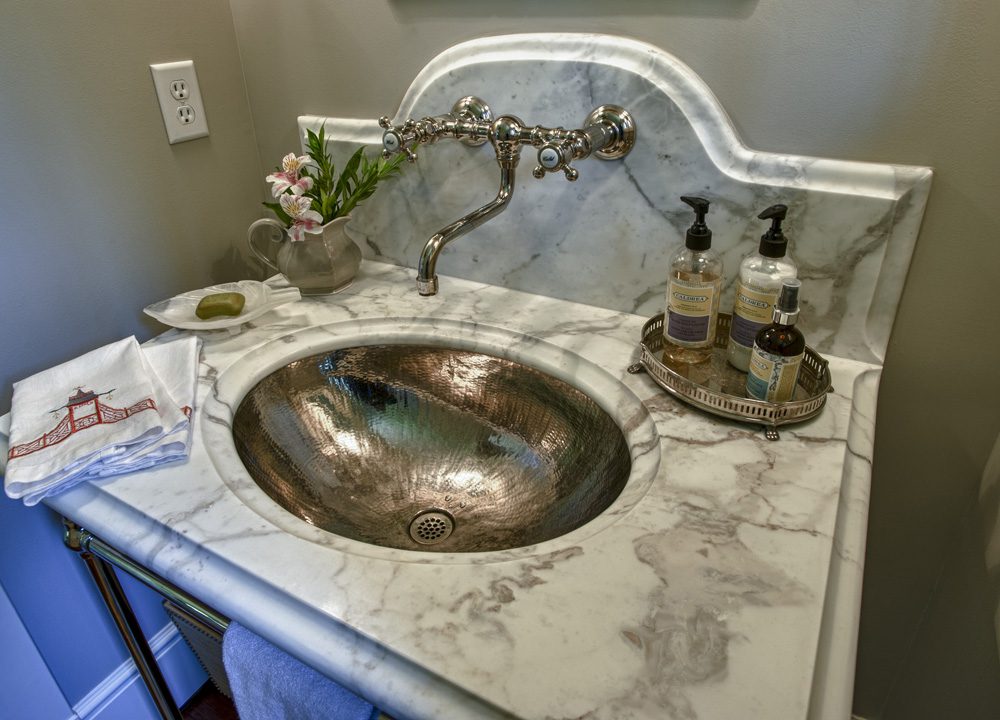 A bathroom sink with soap and lotion on the counter.