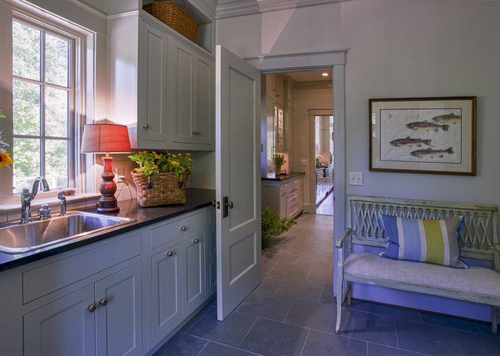 A kitchen with white cabinets and blue walls.