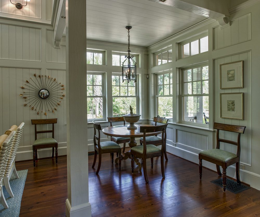A dining room with hard wood floors and white walls.