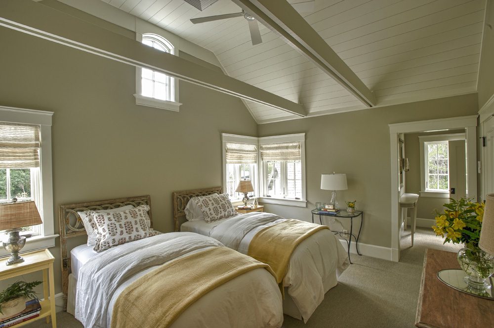 A bedroom with two beds and a large window.