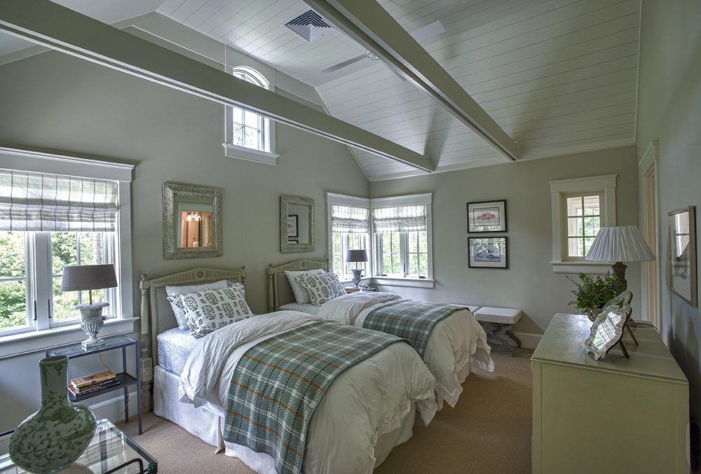 A bedroom with two beds and a dresser.