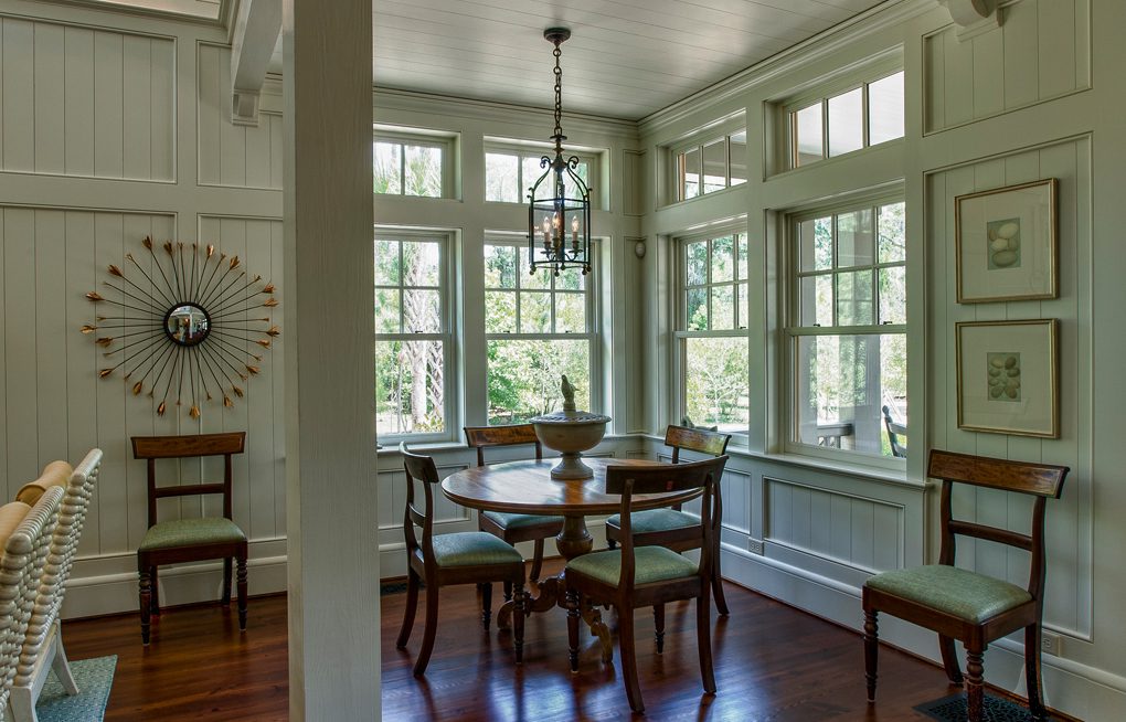 A dining room with many windows and chairs.